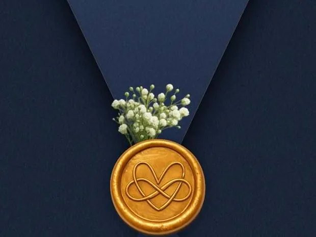 A navy envelope closed with a gold wax seal and a sprig of baby's breath