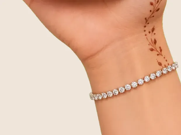 A wrist with a diamond bracelet and a fine mehendi vine