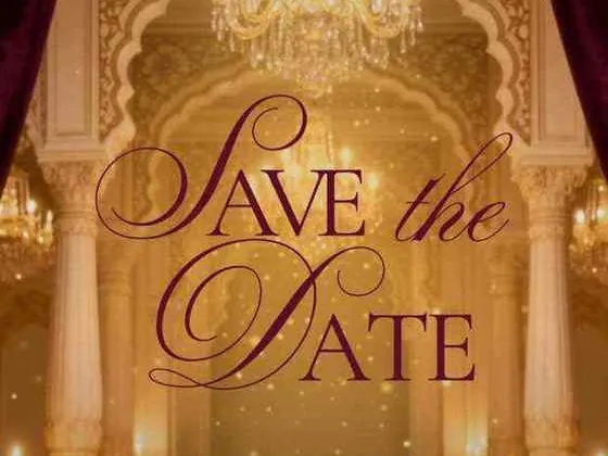Save the Date lettered in gold under chandeliers
